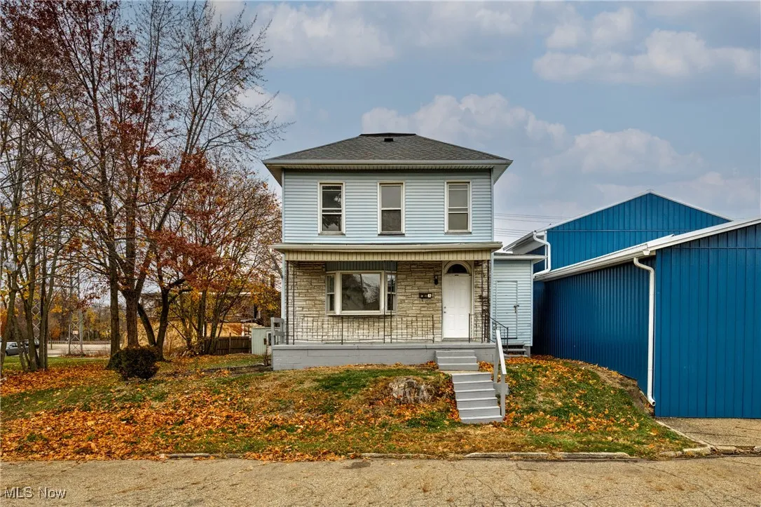 View of front of property featuring covered porch and stone siding