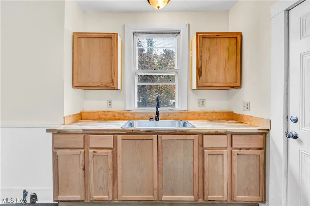 Kitchen with light countertops and light brown cabinetry