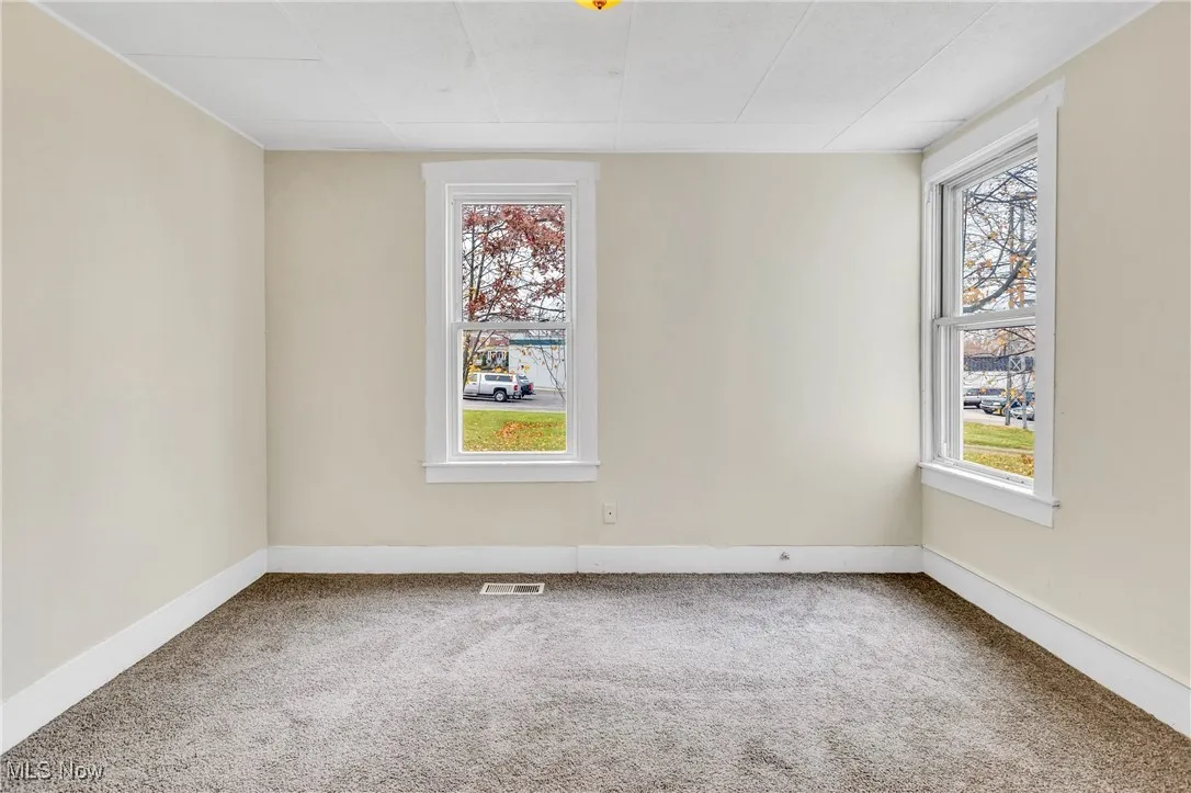Carpeted empty room featuring baseboards