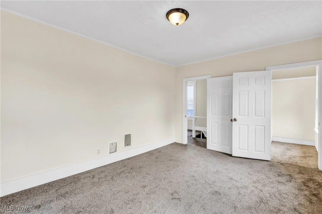 Unfurnished bedroom with carpet floors and baseboards