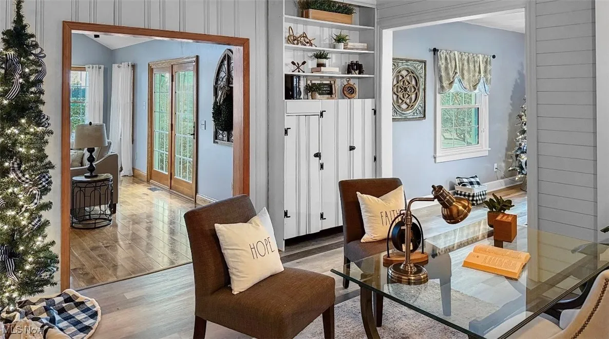 Living area featuring light wood-style flooring, plenty of natural light, and wood walls