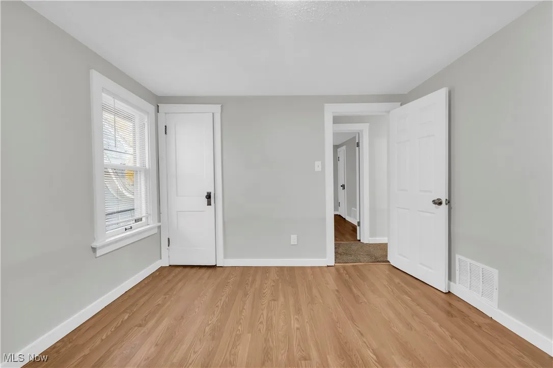 Unfurnished bedroom with baseboards and light wood-style floors