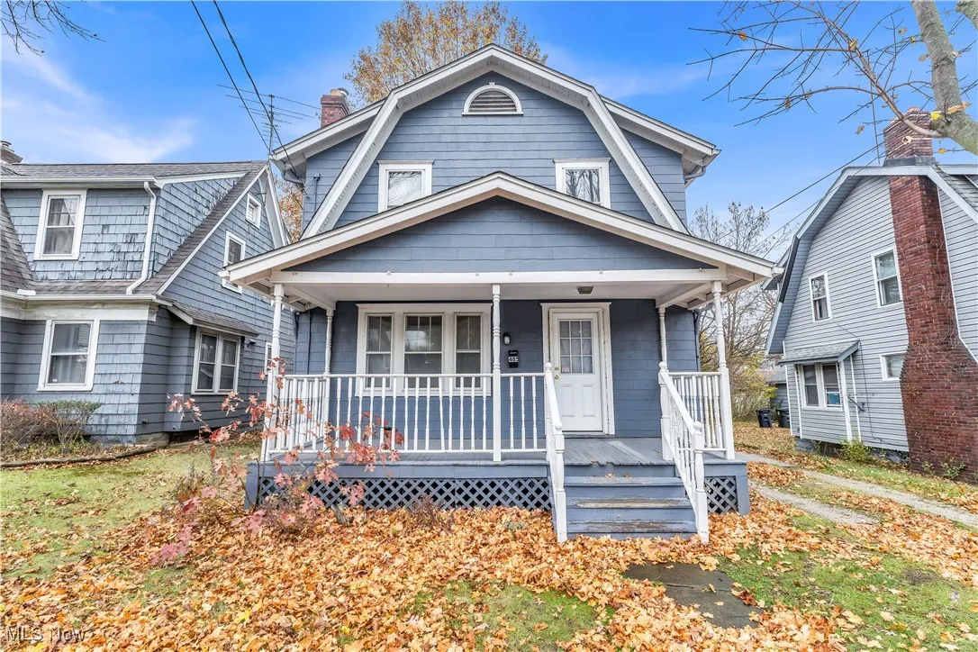 Dutch colonial featuring a porch, a gambrel roof, and a chimney