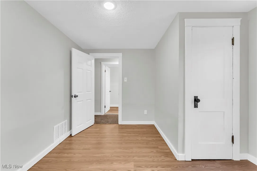 Empty room featuring a textured ceiling and light wood finished floors
