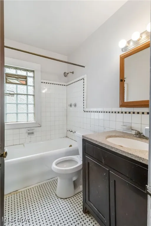 2nd floor Bathroom featuring  shower combination, vanity, and tile walls