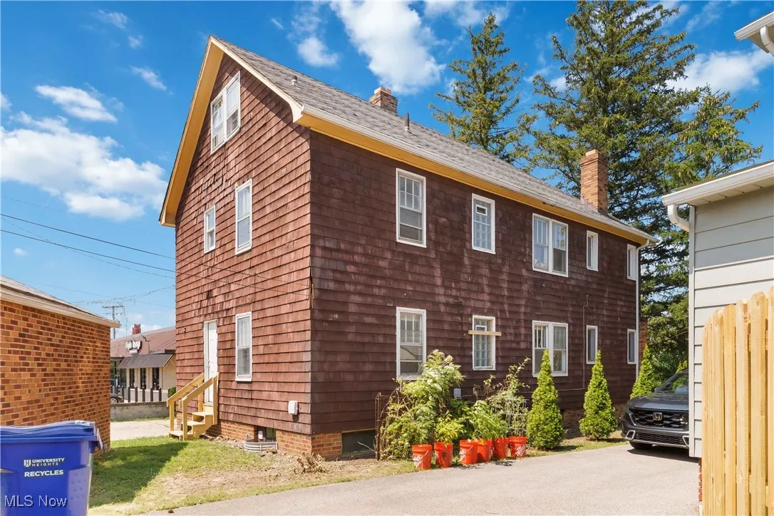 View of side of property featuring a chimney and a shingled roof