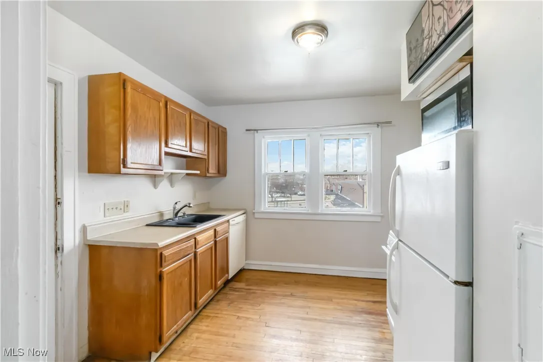 2nd floor Kitchen with white appliances, light countertops, light wood-style flooring, and brown cabinets