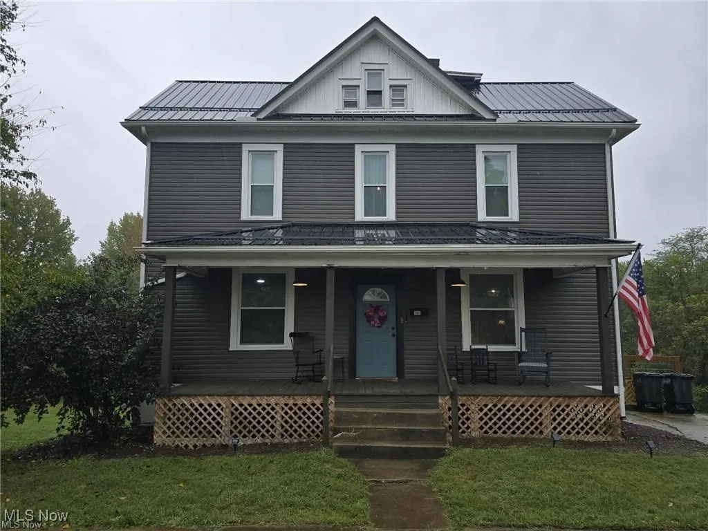 View of front facade featuring covered porch and a front yard