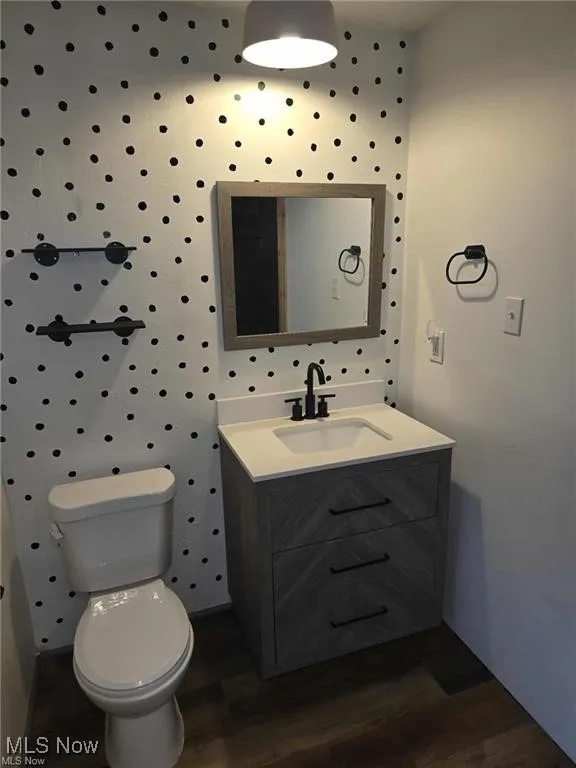 Half bath with vanity and dark wood-style flooring