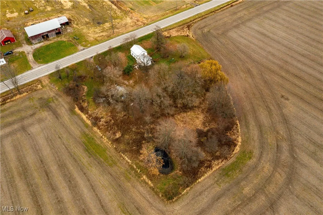 Aerial view of property and surrounding area with rural landscape and rows of crops