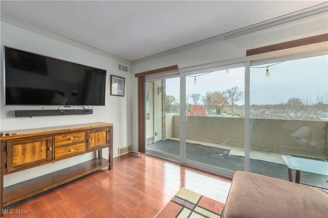 Living area featuring wood finished floors and crown molding