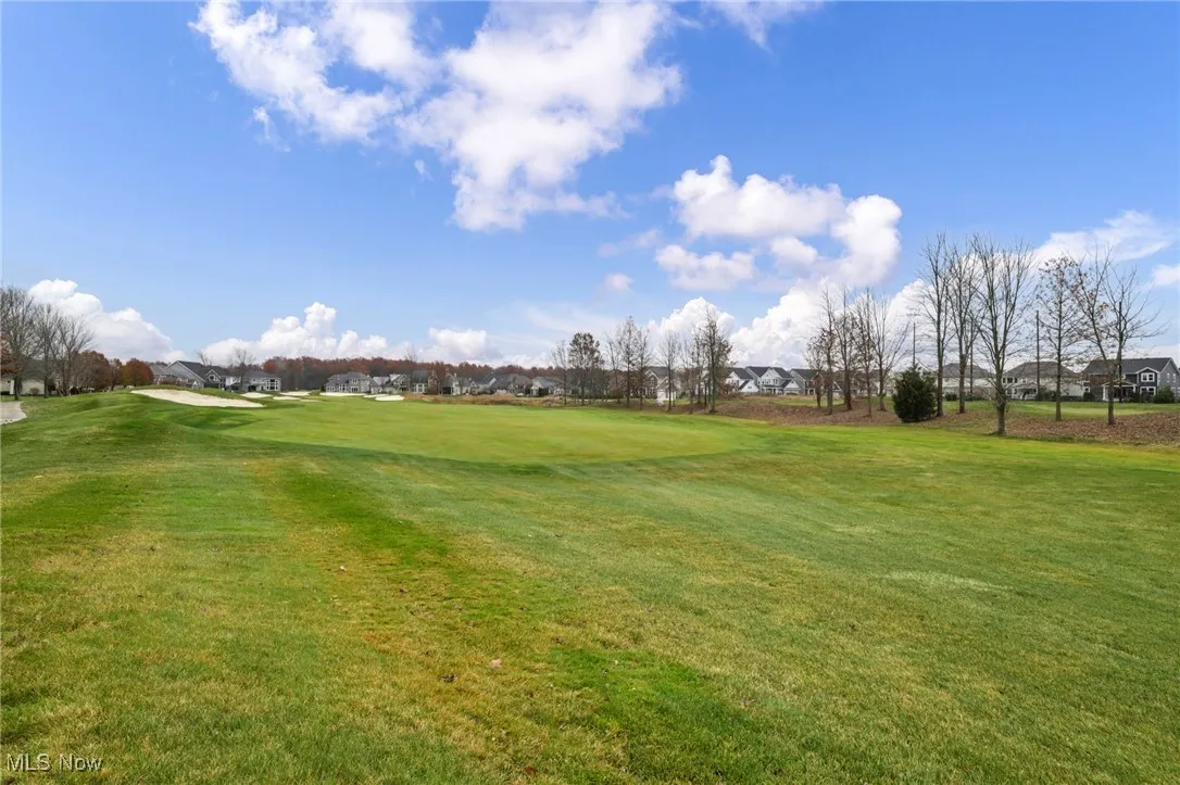 View of green lawn featuring view of golf course