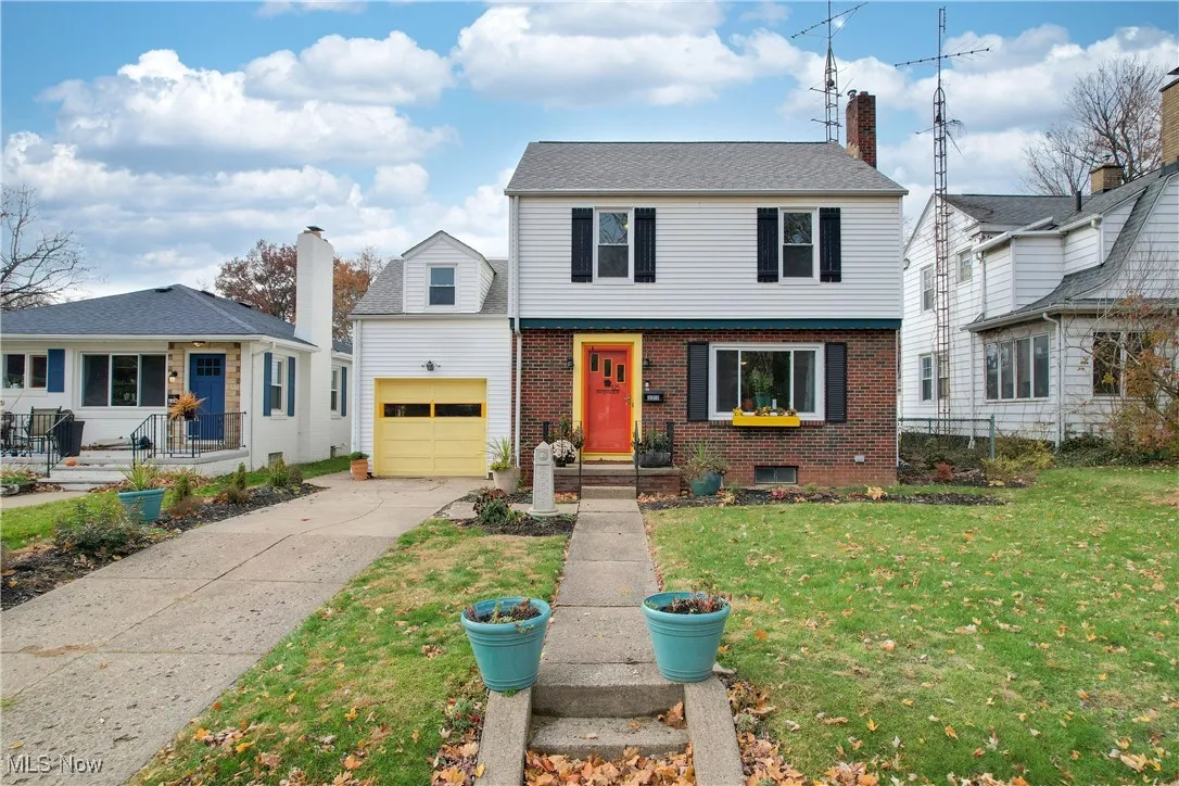 Colonial inspired home with brick siding, driveway, and a garage