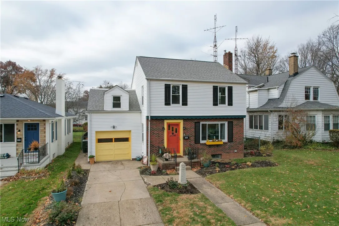 View of front of house featuring a front lawn, brick siding, a garage, and concrete driveway