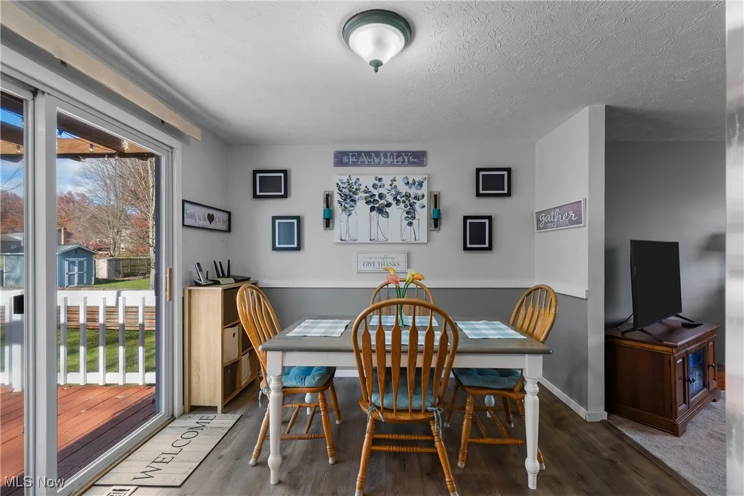 Kitchen eating area with sliding doors to the deck featuring wood laminate floors and a textured ceiling