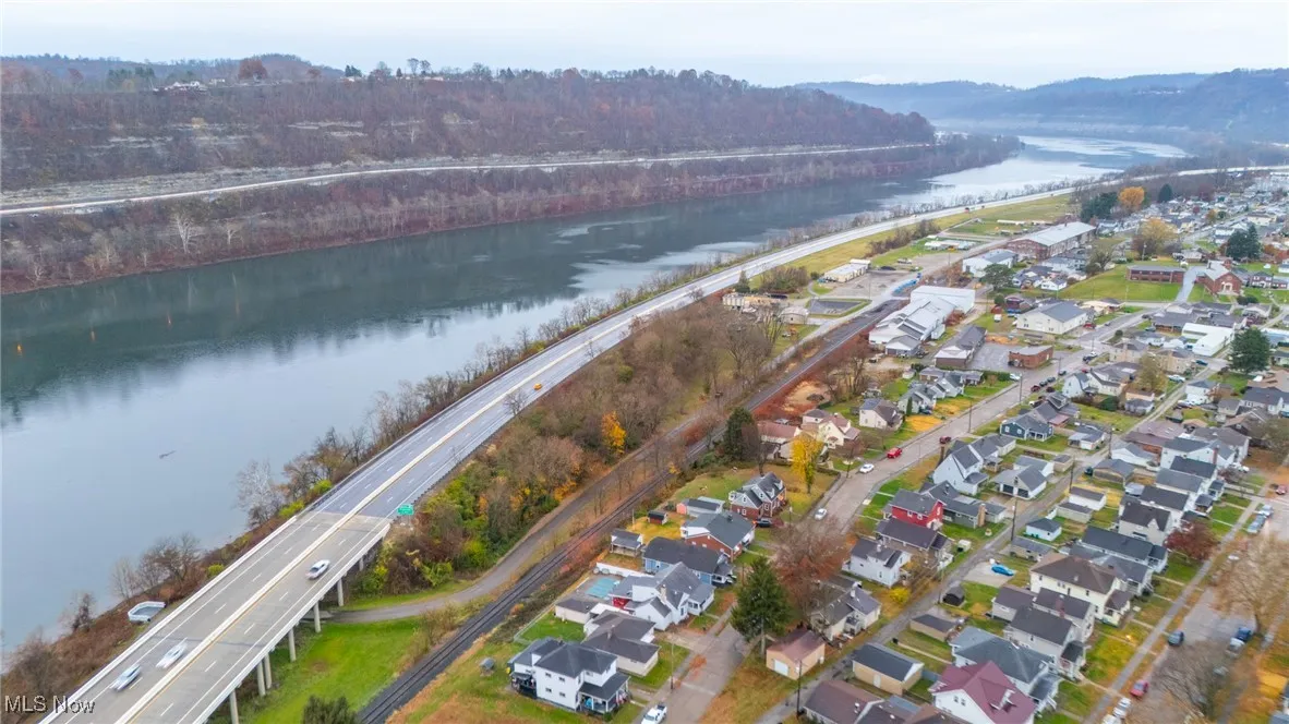 Aerial overview of property's location featuring a nearby body of water and nearby suburban area
