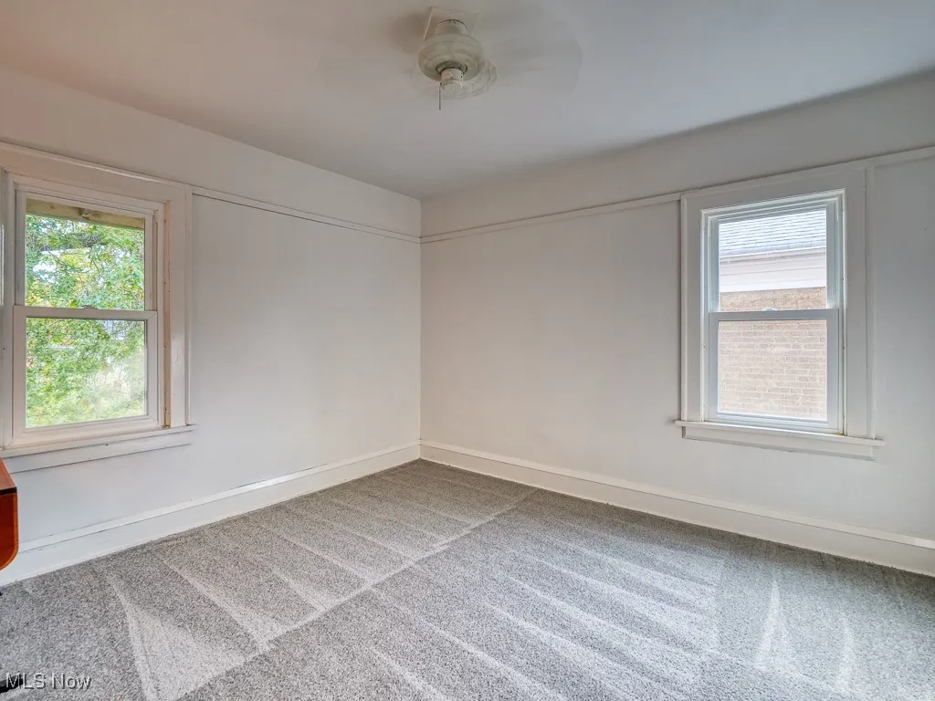 Empty room with carpet flooring and a ceiling fan