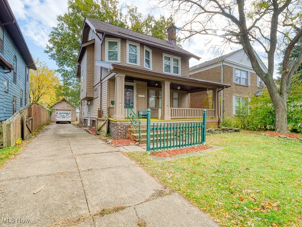 View of front of home featuring a chimney, a porch, and a detached garage