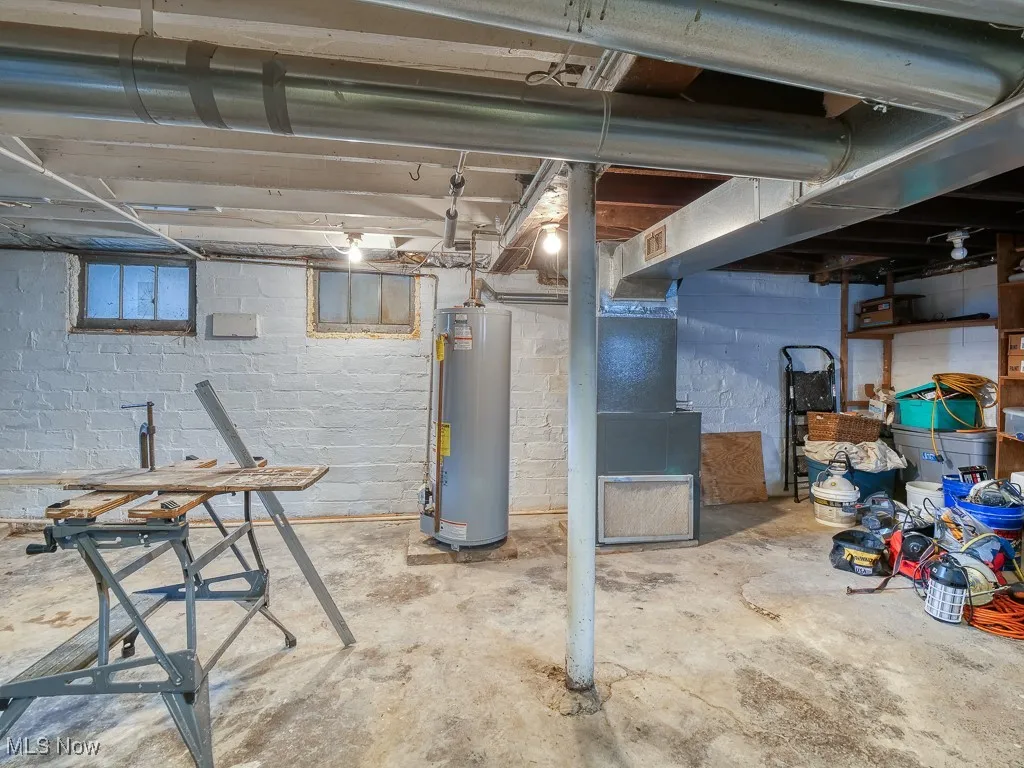 Unfinished below grade area with gas water heater and heating unit