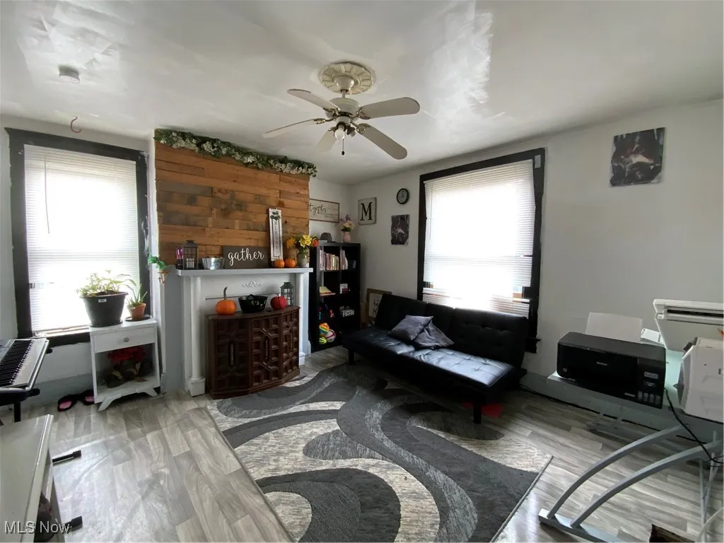Living room with light wood-type flooring and ceiling fan
