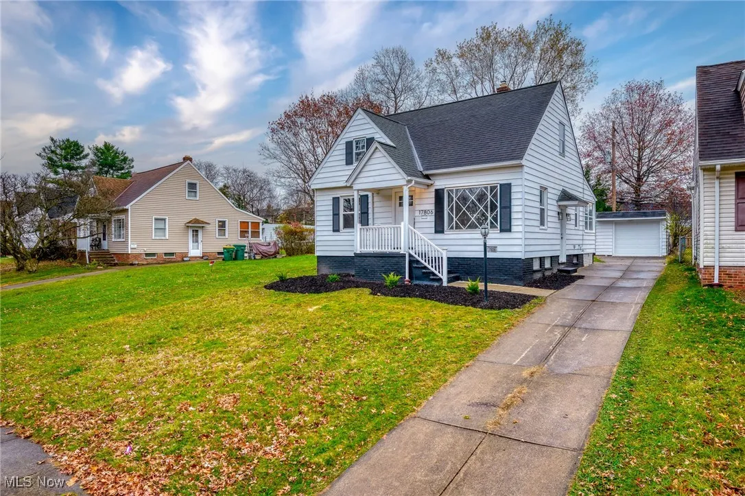 Bungalow with an outdoor structure, a front lawn, a garage, and a shingled roof