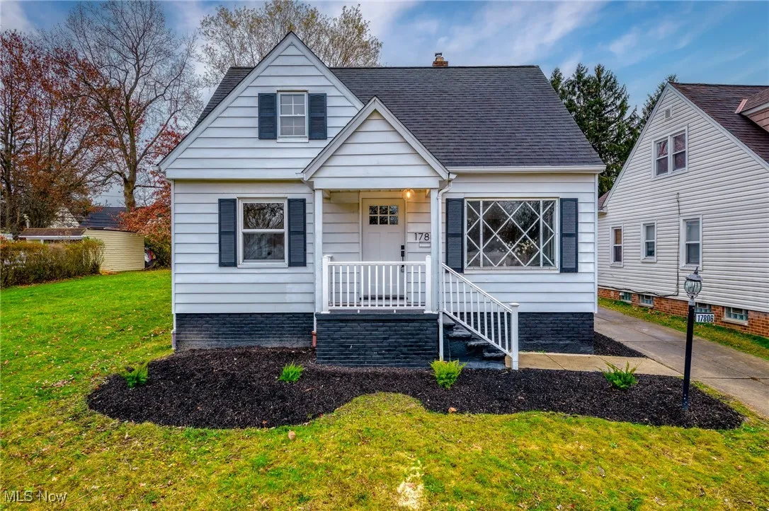 Bungalow featuring a front yard, covered porch, a chimney, and roof with shingles