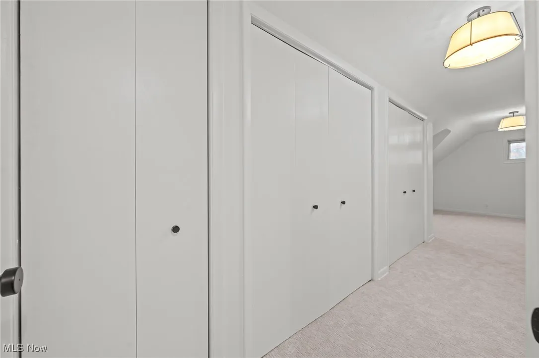 Hall featuring light carpet and lofted ceiling