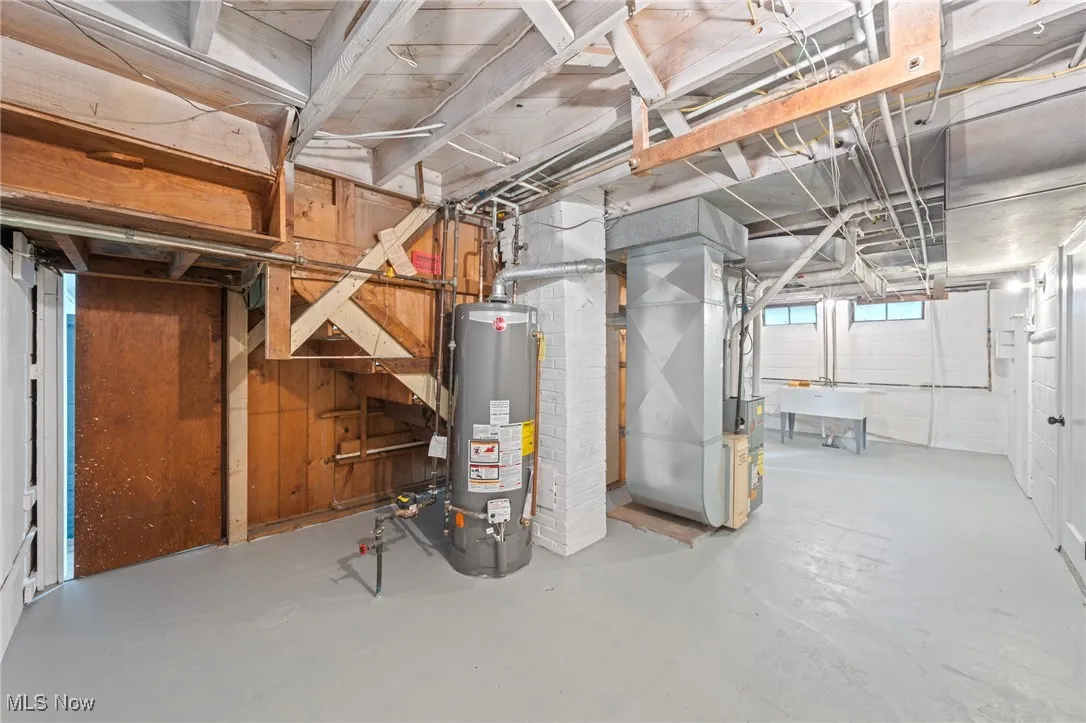 Below grade area featuring water heater and heating unit