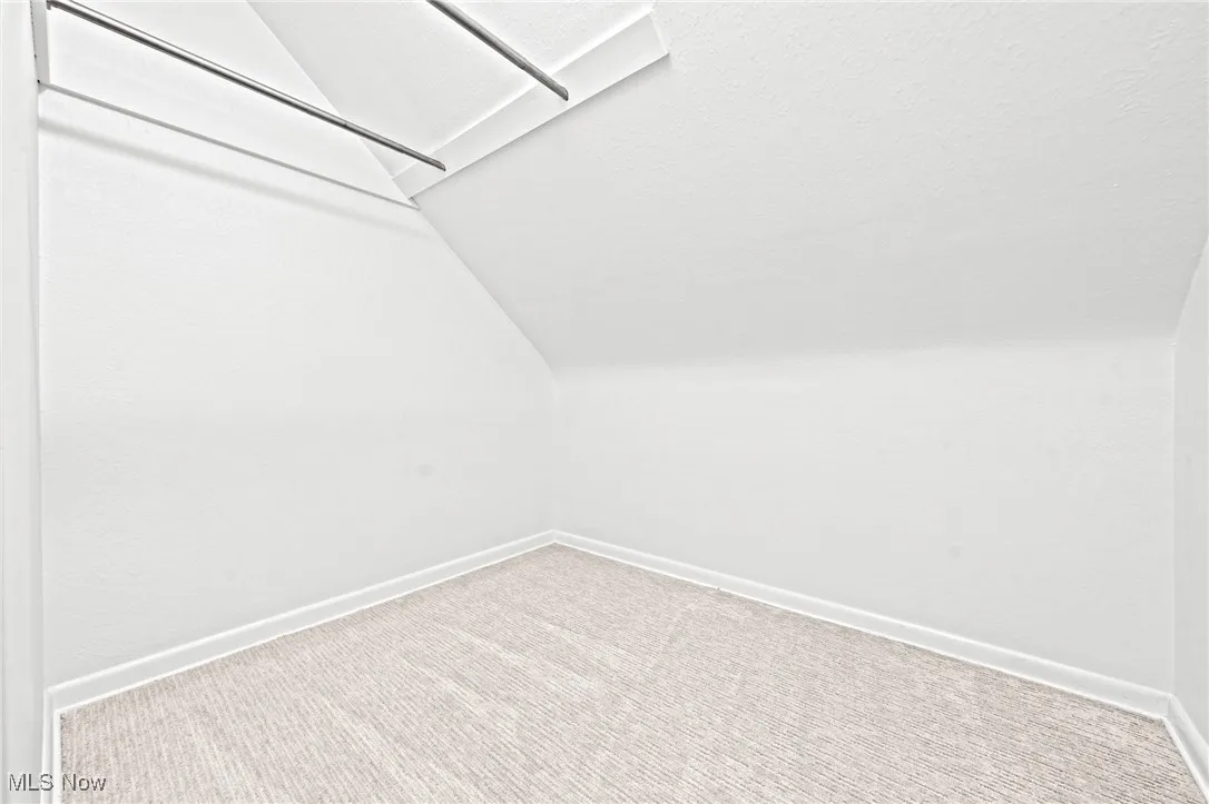 Walk in closet featuring carpet floors and lofted ceiling