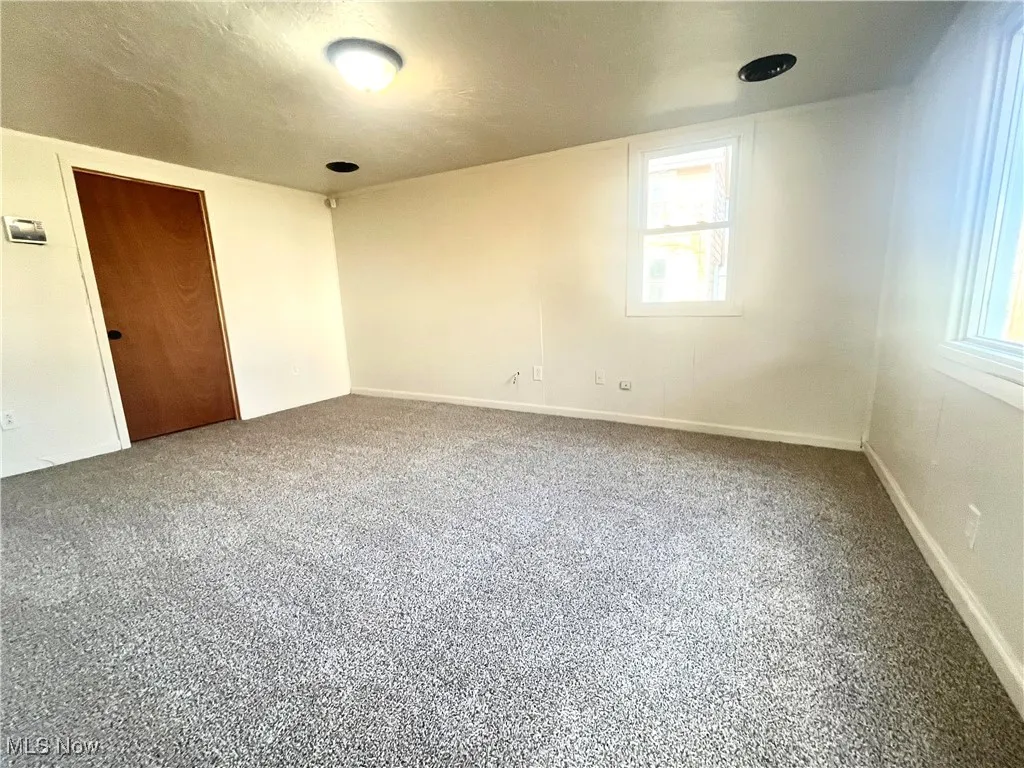 Unfurnished room featuring carpet floors and a textured ceiling