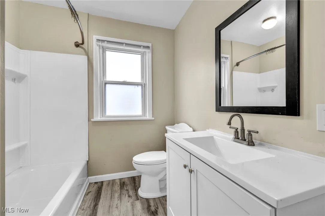 Bathroom featuring vanity, light wood-style floors, and shower / washtub combination