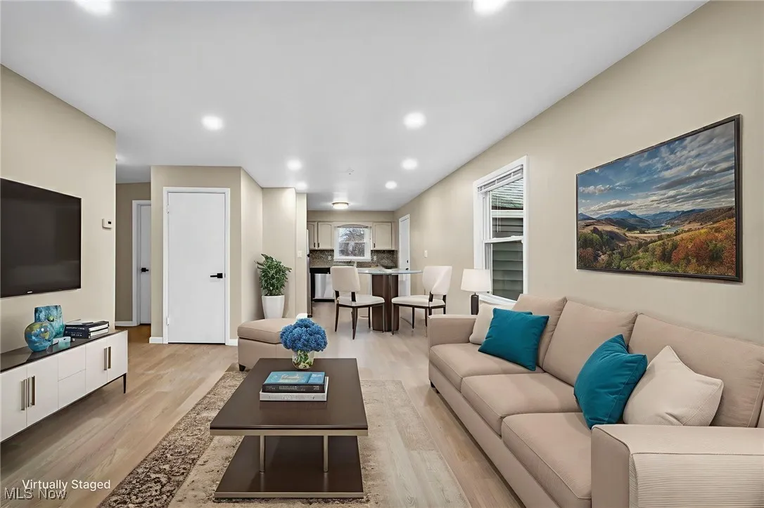 Living room with light wood-style floors and recessed lighting
