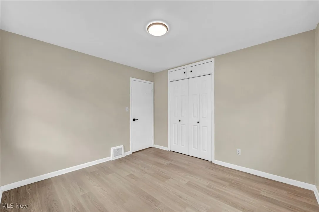 Unfurnished bedroom with light wood-style flooring and a closet