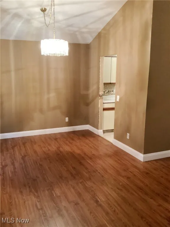 Unfurnished dining area with wood finished floors and lofted ceiling