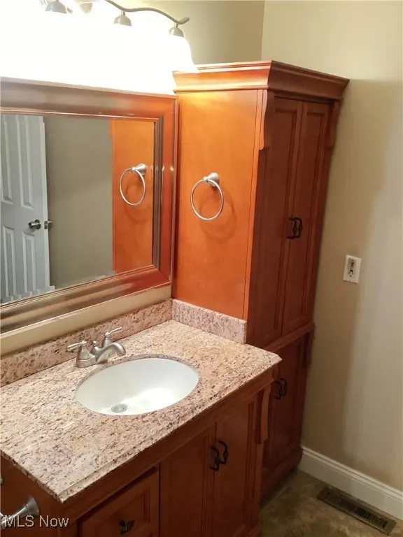 Bathroom with vanity and baseboards