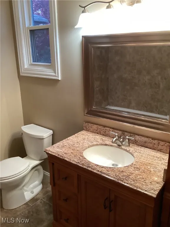 Bathroom with vanity and dark tile patterned floors