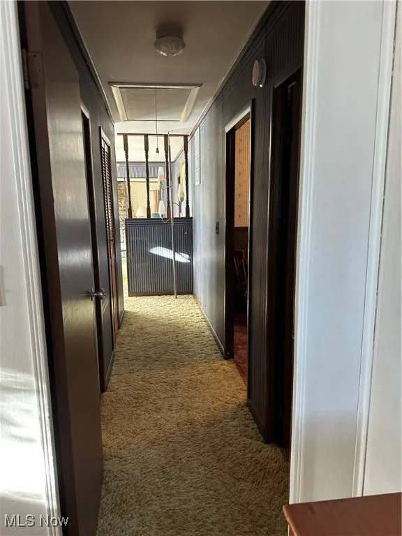 Hallway with carpet floors and attic access
