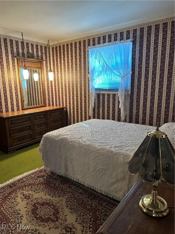 Carpeted bedroom featuring crown molding