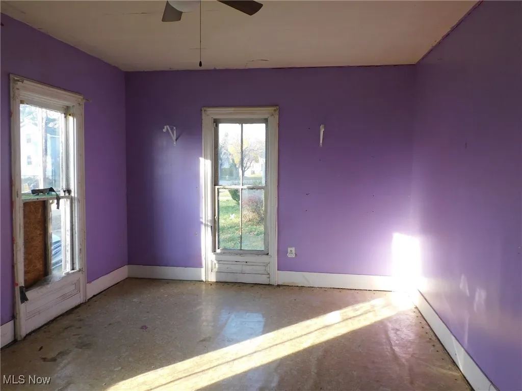 bedroom 1 1st floor A with healthy amount of natural light, concrete floors, and ceiling fan