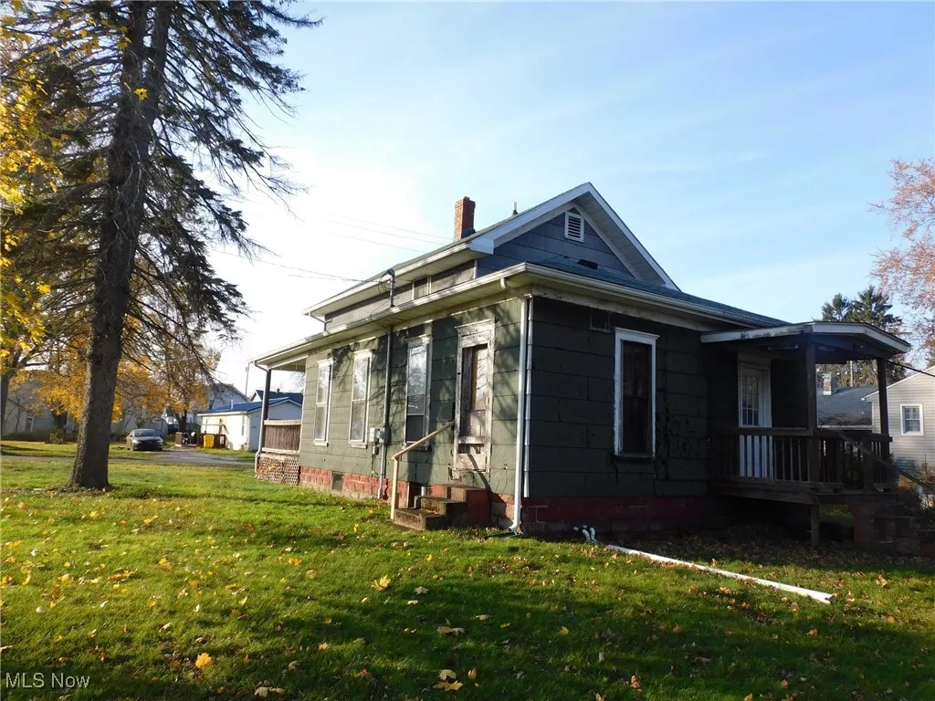 back right View of side of home with a yard and a chimney