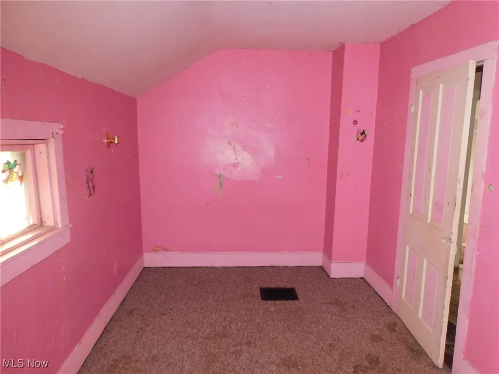 bedroom 4 up view B featuring dark colored carpet and vaulted ceiling