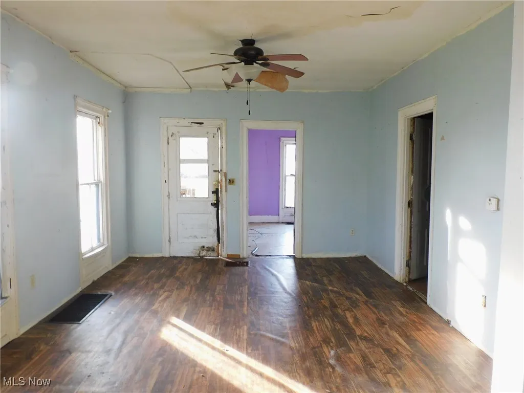living room view B with dark wood finished floors and a ceiling fan