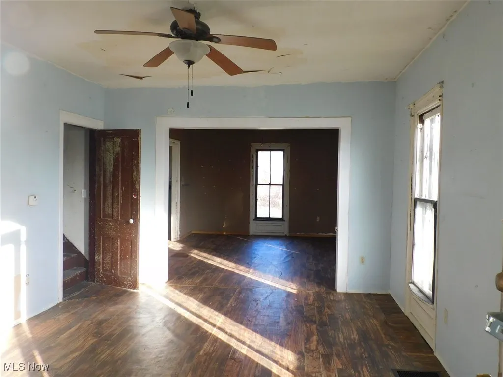 living room  A featuring dark wood finished floors and ceiling fan