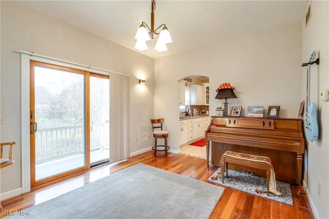 Sitting room featuring a chandelier, light wood-style flooring, and arched walkways