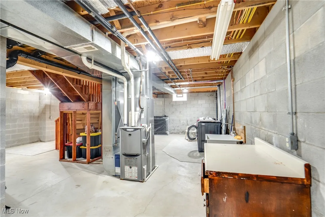 Unfinished below grade area featuring heating unit