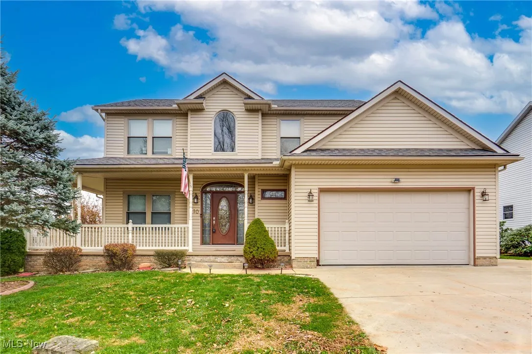 View of front of property featuring a porch, a front yard, concrete driveway, and a shingled roof