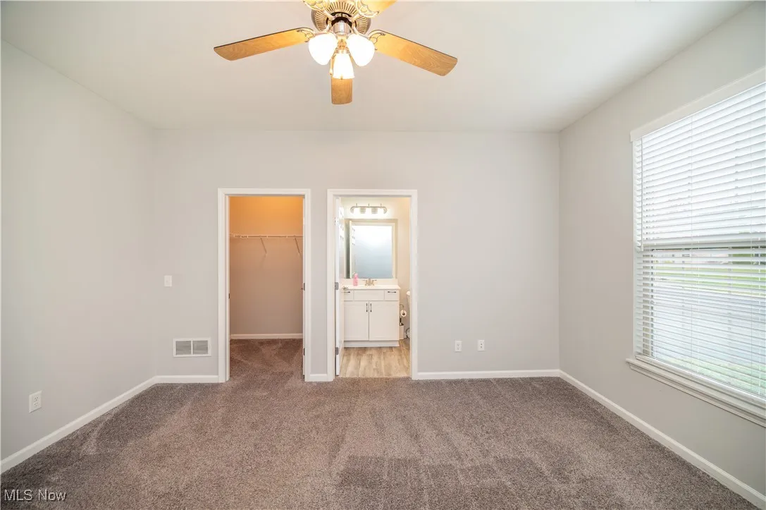 Second bedroom with ceiling fan, carpet, closet and bathroom