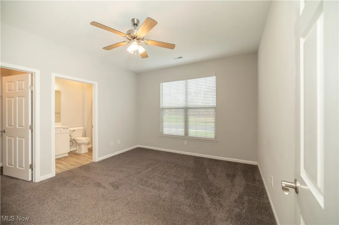 Second bedroom with ceiling fan and carpet