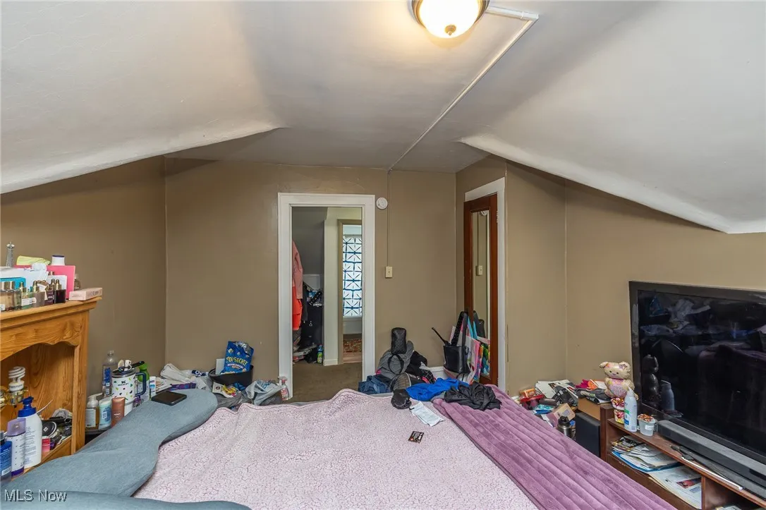 Bedroom with vaulted ceiling and carpet