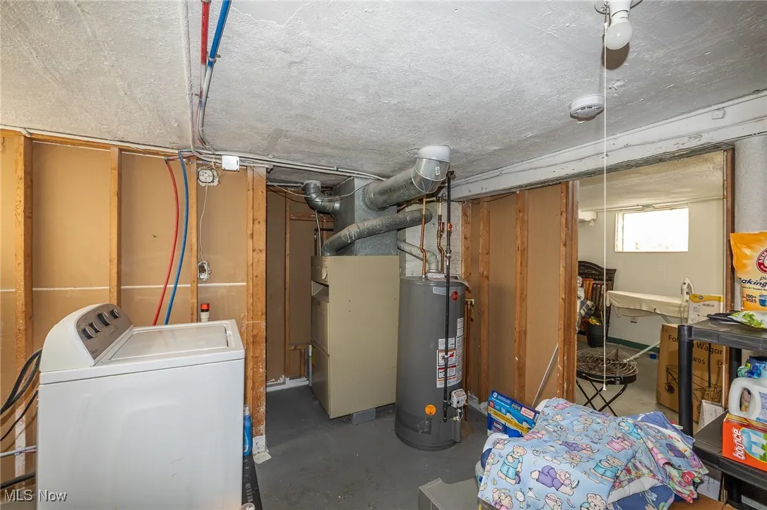 Below grade area featuring washer / clothes dryer, gas water heater, and heating unit